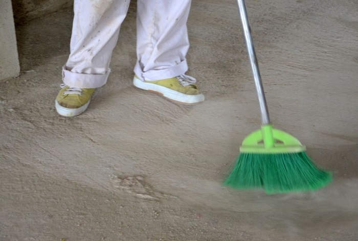 cleaning concrete floor with a broom