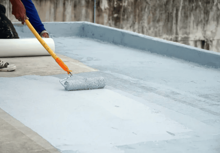 contractor applying gray waterproofing