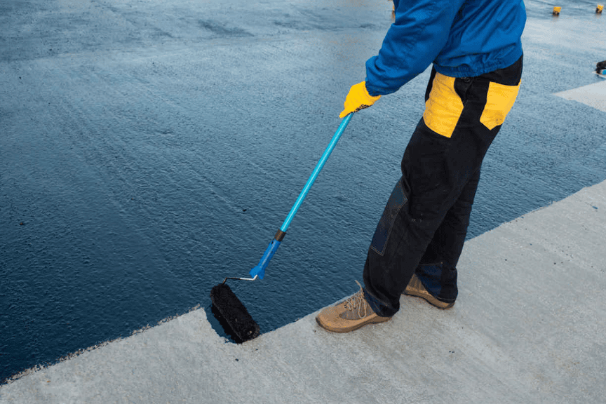 contractor applying black waterproofing