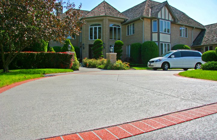 Beautiful residential home with decorative concrete driveway and red brick border