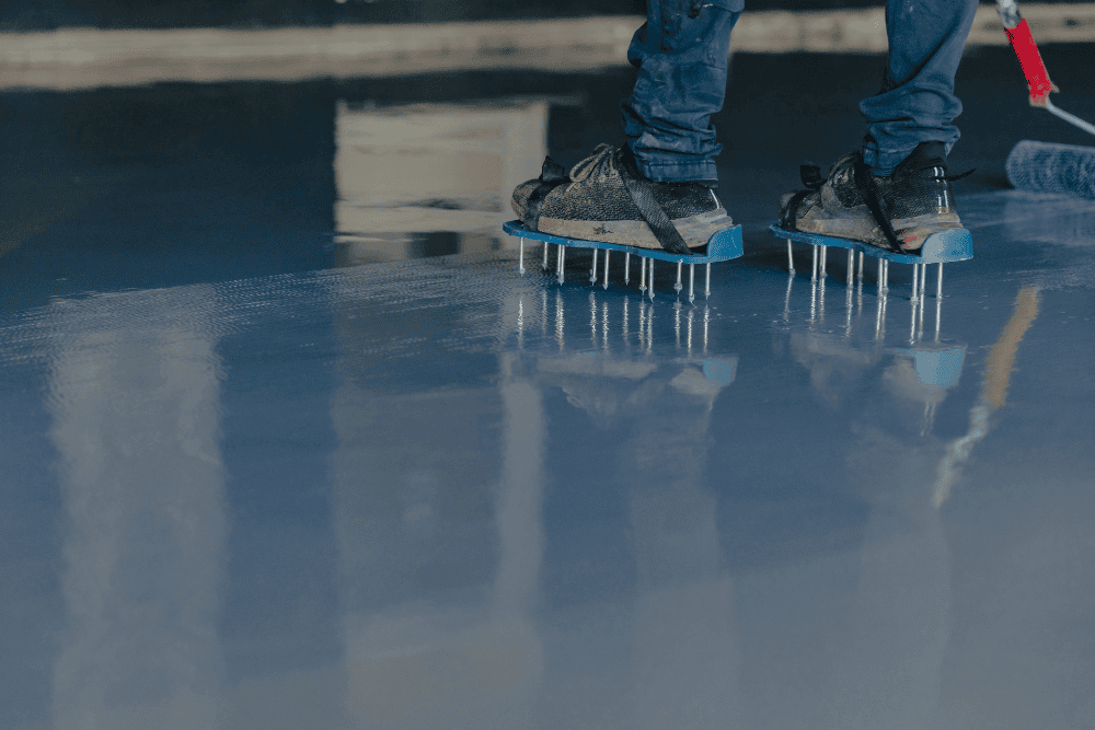 contractor applying epoxy coatings on a concrete floor