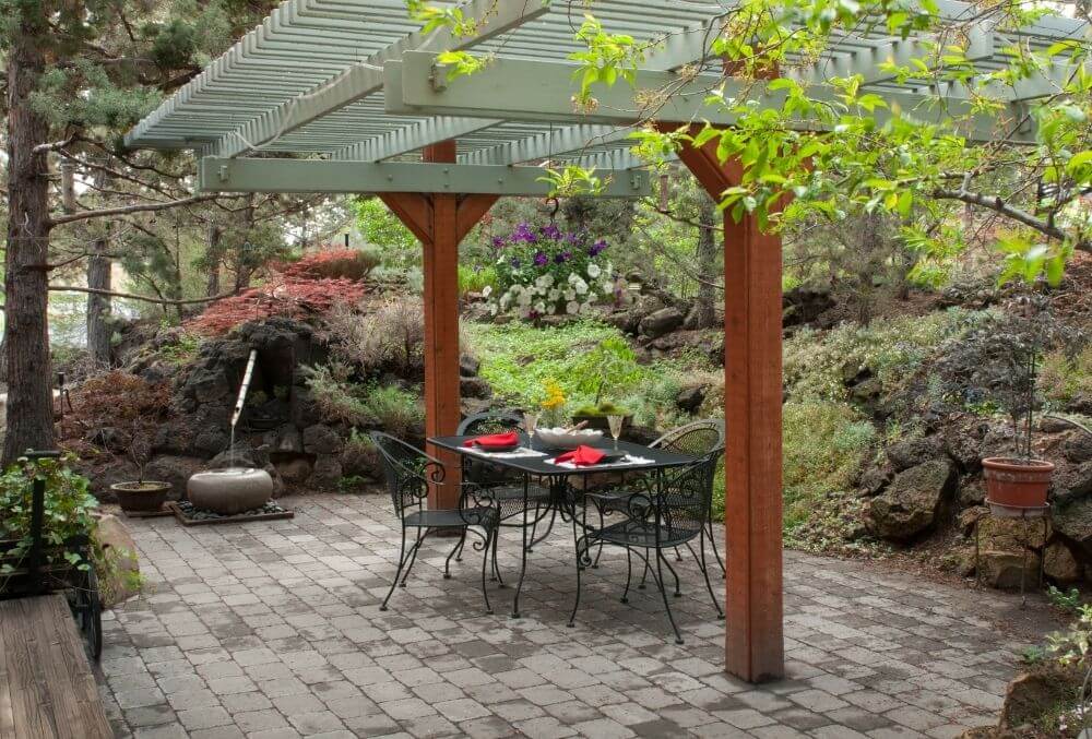 concrete patio with chairs, tables, and a shed