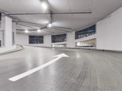 Concrete parking ramp with protective traffic membrane for waterproofing and durability.