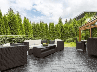 Backyard patio with stamped concrete flooring designed to look like natural stone