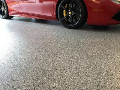 Shiny epoxy garage floor with a sleek red sports car parked on a clean, durable surface.