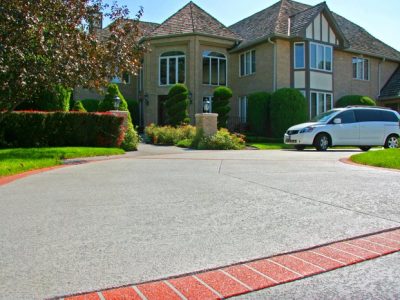 Beautiful residential home with decorative concrete driveway and red brick border