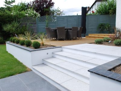 Concrete deck with stairs featuring a durable, slip-resistant surface and decorative finish, providing a seamless transition between outdoor levels.