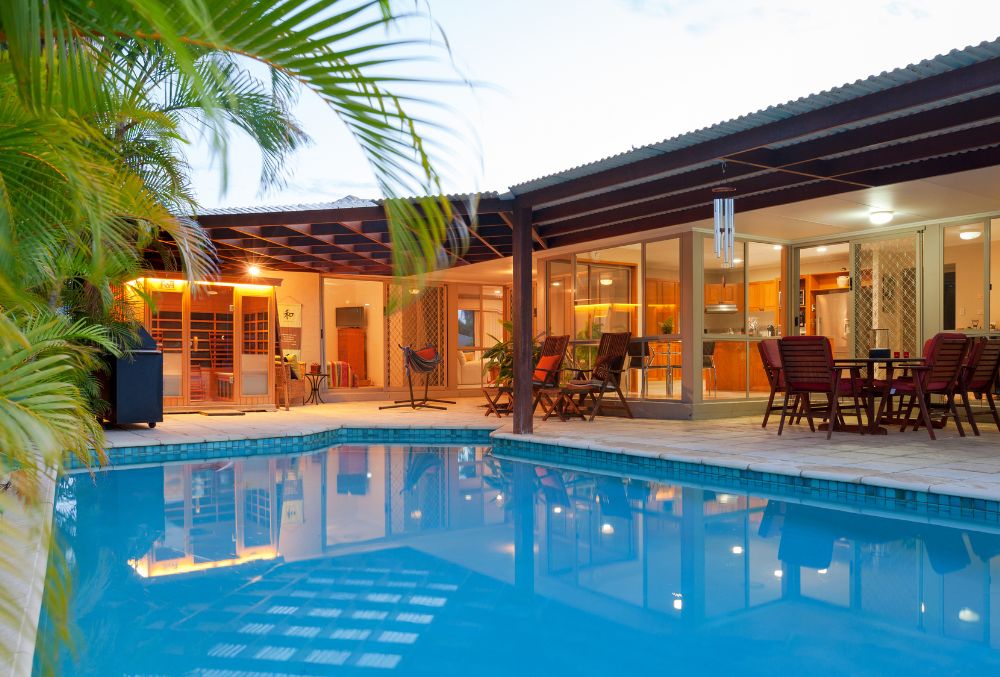 swimming pool with a patio area, elegantly lit