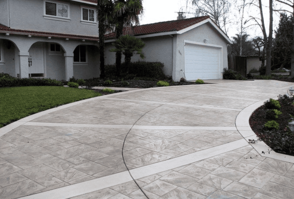 concrete driveway leading to a garage white house